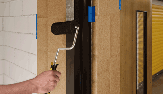 Applying paint to a door frame with a PURDY roller
