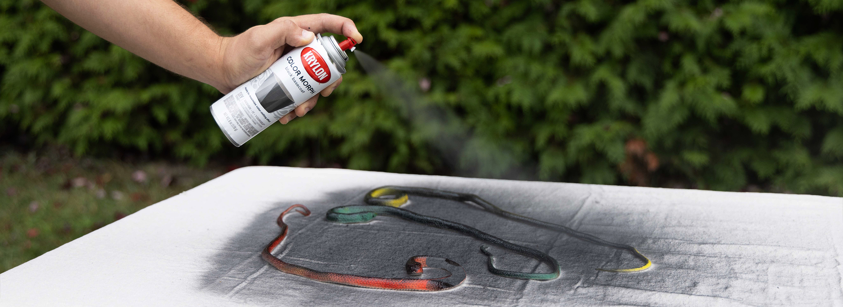 Spraying rubber snakes with Krylon black basecoat